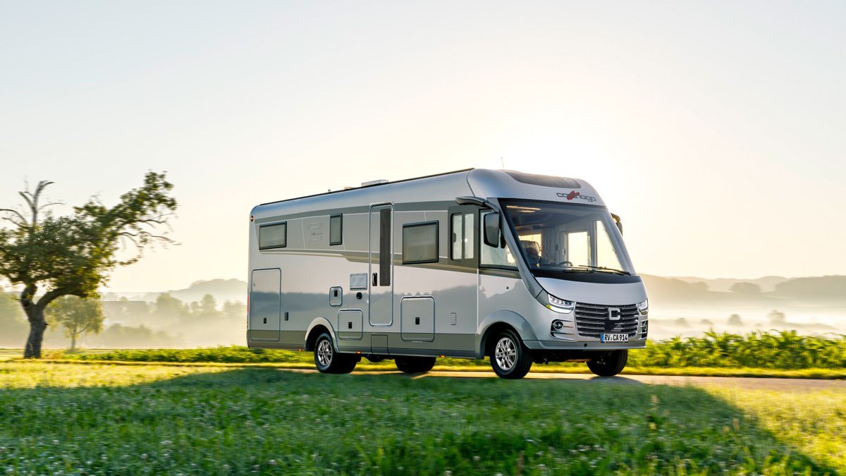 Carthago Wohnmobil s-plus auf einer Wiese mit blauem Himmel