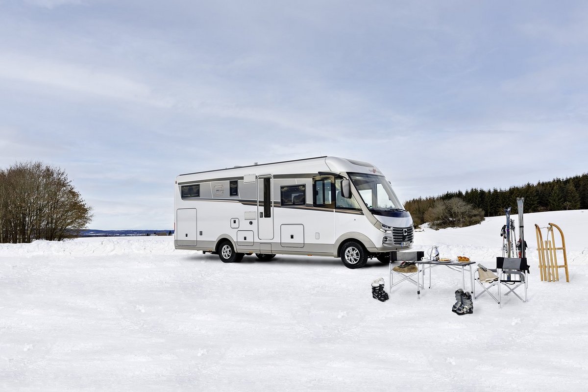 Carthago Wohnmobil s-plus von der Seite in einer Schneelandschaft