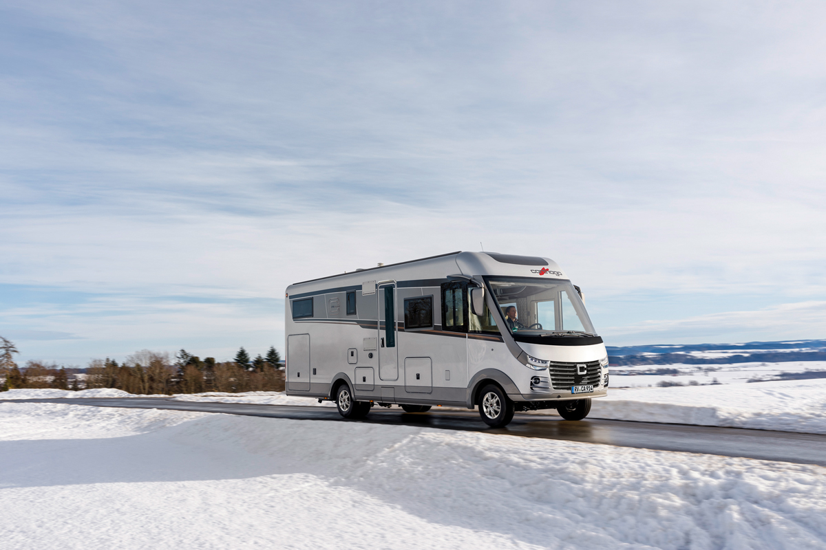 Schneelandschaft Carthago Wohnmobil s-plus fahrend auf der Straße 